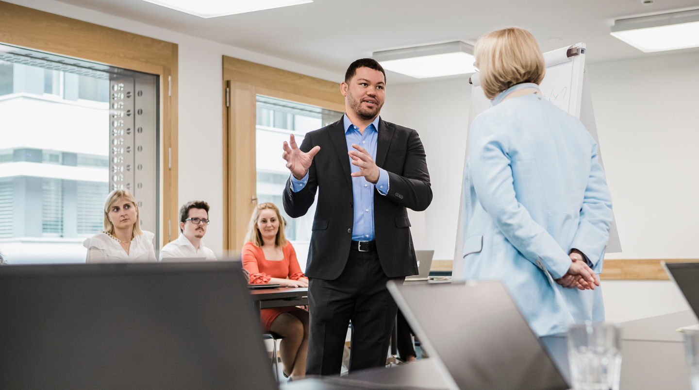 Trainer spricht über Antirassismus-Training vor einer Gruppe von Teilnehmenden