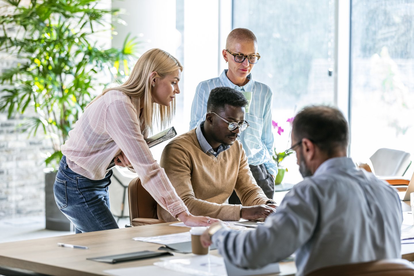 Diverse Gruppe von Personen diskutiert über Diversity Benchmarking in einem modernen Büro